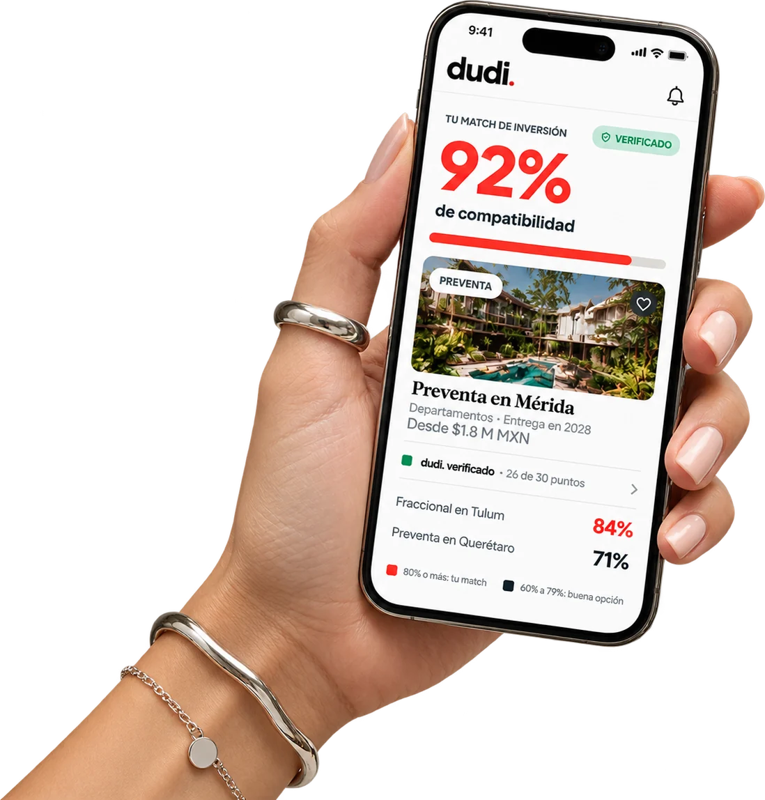 Mano sosteniendo un celular con dudi: Preventa en Mérida con 92% de compatibilidad y dudi verificado con 26 de 30 puntos revisados; también Fraccional en Tulum con 84% y Preventa en Querétaro con 71%.